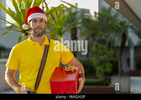 Brasilianische mailman verkleidet als Weihnachtsmann ein Geschenk. Online kaufen In der Auslieferung. Stockfoto