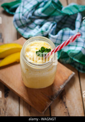 Mango Smoothie in einem Glas auf hölzernen Tisch Stockfoto