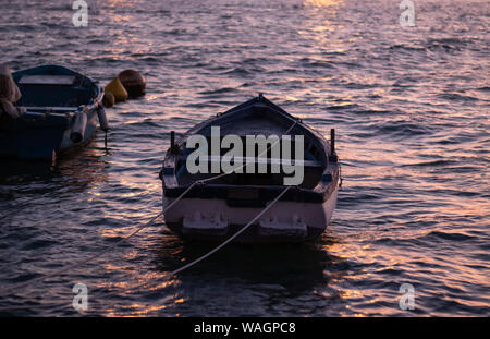 Zwei kleine Boote schwimmend im Meer bei Sonnenuntergang Stockfoto