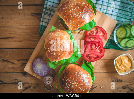 Nahaufnahme der hausgemachten Burger auf Schneidebrett, Ansicht von oben Stockfoto