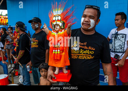 Lokale Leute warten mit Ihren Santo Nino Statuen für die Prozession beginnen, Ati-Atihan-Festival, Kalibo, Panay Island, Philippinen. Stockfoto