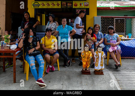 Lokale Leute warten mit Ihren Santo Nino Statuen für die Prozession beginnen, Ati-Atihan-Festival, Kalibo, Panay Island, Philippinen. Stockfoto