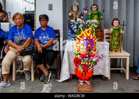 Lokale Leute warten mit Ihren Santo Nino Statuen für die Prozession beginnen, Ati-Atihan-Festival, Kalibo, Panay Island, Philippinen. Stockfoto