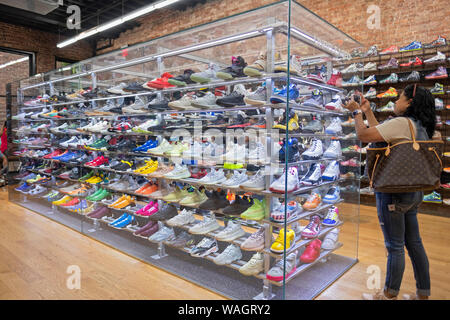 Eine Frau braucht ein Handy Foto von seltenen teuer unveröffentlichten Sportschuhe an der Flight Club am Broadway in Greenwich Village, New York City. Stockfoto