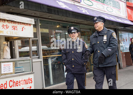 Zwei asiatische amerikanische Hilfspolizisten gehen Sie die Hauptstraße zu plaudern. In Chinatown, Flushing, Queens, New York. Stockfoto