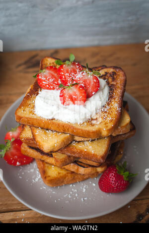 In der Nähe von French Toast mit frischen Erdbeeren, Coconut zerfetzt und Honig, auf hölzernen Hintergrund Stockfoto