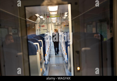 15. August 2019, Schleswig-Holstein, Westerland/Sylt: Ein Dirigent Spaziergänge durch einen regionalen Zug des nahverkehrsverbunds Schleswig-Holstein GmbH (nah.sh GmbH) auf dem Weg zwischen Westerland auf der Insel Sylt und Hamburg. Foto: Christian Charisius/dpa Stockfoto