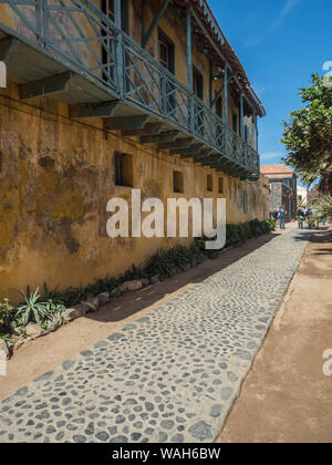 Goree, Senegal - Februar 2, 2019: Alltag und Straße mit Kopfsteinpflaster Straße zwischen Bunte Häuser auf der Insel Goree. Gorée. Dakar, Seneg Stockfoto