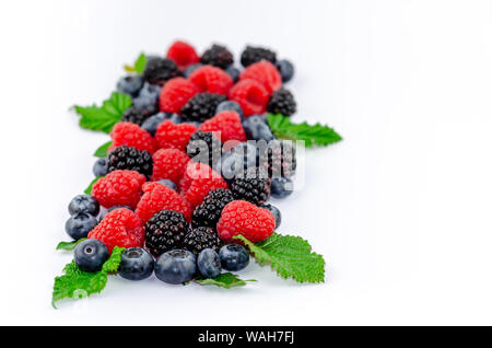 Blaubeeren, Brombeeren, Himbeeren und grüne Blätter auf Weiß isoliert. Stockfoto