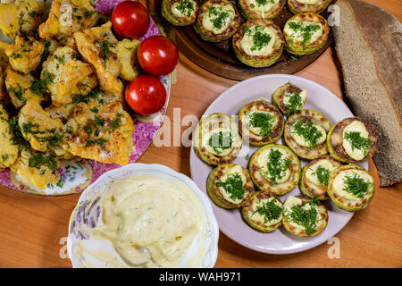 Hausgemachte Blumenkohl in Teig und Zucchini mit Sauce Tartar und Tomaten Stockfoto