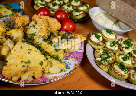 Hausgemachte Blumenkohl in Teig und Zucchini mit Sauce Tartar und Tomaten Stockfoto