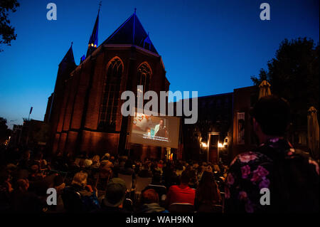 Nijmegen, Gelderland, Niederlande. 20 Aug, 2019. Die Menschen sitzen draußen, während einer der Filme von Quentin Tarantino genießen. Weil der letzte Film von Quentin Tarantino in diesem Monat veröffentlicht wurde, LUX, eine unabhängige und liberale Plattform in Nijmegen für neue Entwicklungen in der Kunst und Kultur angeboten, ein Open-Air-Kino Vorführungen von seinen Bekannten filmen, wie vier Zimmer und Pulp Fiction. Hunderte von Menschen kann man kostenlos die Filme, wie vier Zimmer und Pulp Fiction in einer sehr Tarantino Stil genießen. Credit: Ana Fernandez/SOPA Images/ZUMA Draht/Alamy leben Nachrichten Stockfoto