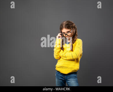 Denken ernst Schülerin in Brillen studio Suchen auf grauem Hintergrund mit leere Raum. Zurück zu Schule. Der Begriff der Bildung. Nahaufnahme Stockfoto