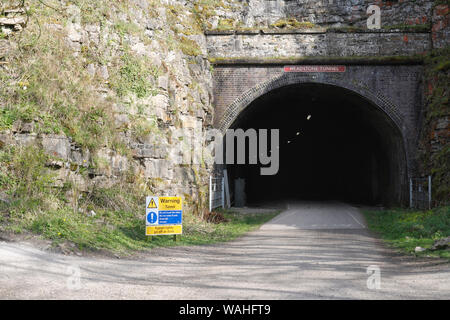 Der Eingang zum Grabsteintunnel auf dem Monsal Trail Fußweg im Derbyshire Peak District, England, unbenutzter Eisenbahntunnel Stockfoto