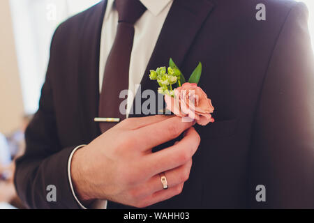 Anstecker in der Form der Rose auf Hochzeit Anzug des Bräutigams. Stockfoto