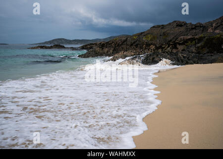 Unbenannte Strand mit Wellen und schwarzen Felsen an der Westküste von Harris, Lewis, Insel, Äußere Hebriden, Schottland, Großbritannien Stockfoto