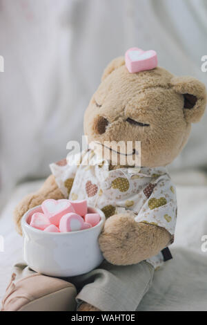 Braun Teddy Bear Holding rosa Herzform Marshmallow Stockfoto