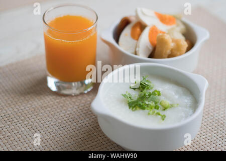 Hot Reis Brei mit Orangensaft zum Frühstück gesetzt Stockfoto
