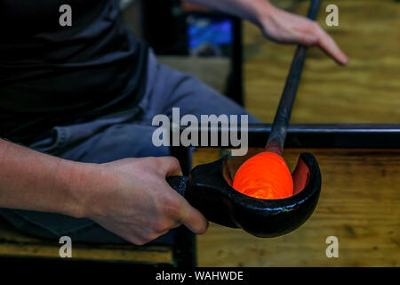 Glasbläser Gestaltung eine Blase aus geschmolzenem Glas auf einem Stab mit der Hand in der Fertigung an die Werkstatt eines Glas Teekocher, geringe Tiefenschärfe Stockfoto