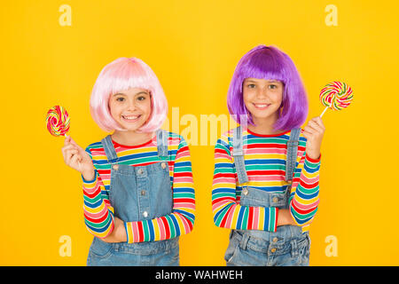 Anime Cosplay party Konzept. Gerne kleine Mädchen. Anime Fan. Kinder mit künstlichen Frisuren essen Lutscher. Anime Convention. Lebendige Zeichen phantastische Themen. Moderne Kindheit. Tag der Kinder. Stockfoto