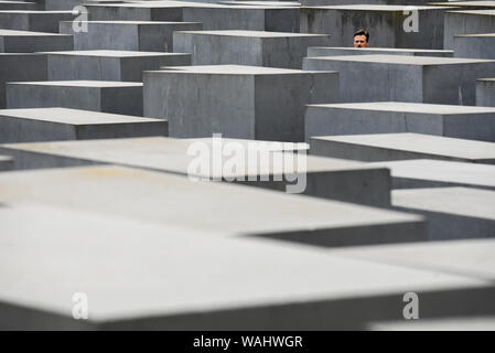 Die Besucher gehen durch Hunderte von betonplatten oder Der telae "Teil des Denkmals für die ermordeten Juden Europas "Holocaust Mahnmal" südlich des Brandenburger Tors. Holocaust Mahnmal wurde von amerikanischen Architekten Peter Eisenman entworfen, auf einer Fläche von 19.000 Quadratmetern von 2711 Betonplatten abgedeckt oder telae'. Stockfoto