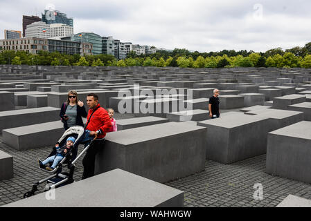 Die Besucher gehen durch Hunderte von betonplatten oder Der telae "Teil des Denkmals für die ermordeten Juden Europas "Holocaust Mahnmal" südlich des Brandenburger Tors. Holocaust Mahnmal wurde von amerikanischen Architekten Peter Eisenman entworfen, auf einer Fläche von 19.000 Quadratmetern von 2711 Betonplatten abgedeckt oder telae'. Stockfoto