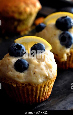 Hausgemachte keto Cupcake aus Mandel- und Walnuss Mehl mit Zitrone und Cashewnüsse Creme mit Blaubeeren closeup eingerichtet. Vertikale, selektive konzentrieren. Stockfoto