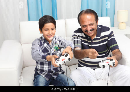 Indische Greis mit seinem Enkel Videospiel zu Hause Stockfoto