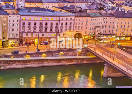 SALZBURG, Österreich - 27. FEBRUAR 2019: Die Linie der mittelalterlichen Häuser mit Blick auf die Ufer der Salzach und Staatsbrucke Brücke, am 27. Februar in S Stockfoto