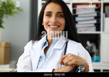 Reife weibliche GP am Werktisch suchen in der Kamera Stockfoto