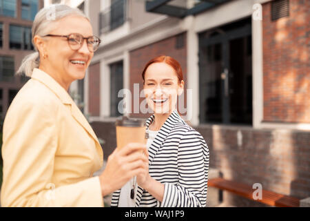 Frauen vor einem Bürogebäude lachen Stockfoto