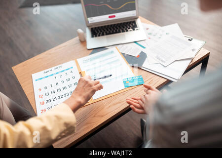 Zwei kaukasischen Geschäftsfrauen saßen und auf Dokumente Stockfoto