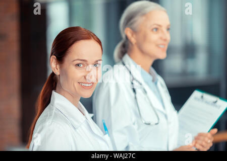 Schöne junge Ärztin im weißen Kittel Stockfoto