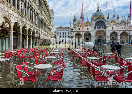 Tische und Stühle an der Procuratie Vecchie und der Basilica di San Marco, während der Acqua Alta (hohe Wasser) Fall, Markusplatz, Venedig, Italien Stockfoto