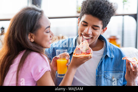 Schöne afrikanische amerikanische Paar teilen Pizza am Tag zu Hause. Stockfoto