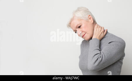 Ältere Frau mit Nackenschmerzen und das Gefühl erschöpft Stockfoto