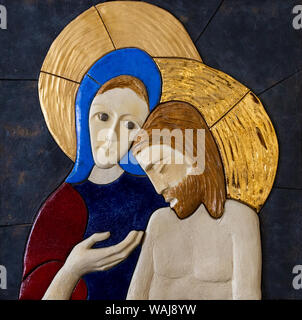 Ein Relief des trauernden Jungfrau Maria über ihren gekreuzigten Sohn Jesus Christus - eine Pieta von lubo Michalko. Stockfoto