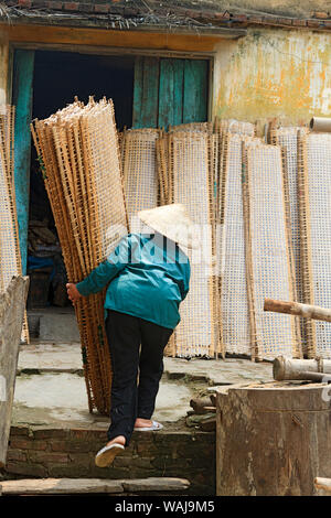 Tho Ha, Vietnam. Frau in traditionellen vietnamesischen Kegel hat die Regale der Trocknung Reis papier (in der Küche verwendet) auf einer kleinen Insel, 50 km nördlich von Hanoi. Stockfoto