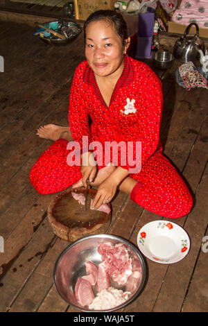 Koh Trong Insel. Junge Frau Vorbereitung Schweinefleisch, Knoblauch und Gemüse für das Abendessen auf der Insel über den Mekong River von Kratie in Kambodscha. (Redaktionelle nur verwenden) Stockfoto