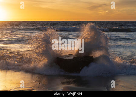Golden Sunset Licht, das durch die weißen Wasser stürzt aus einem Felsen Stockfoto