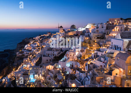 Griechenland, Santorini. Das Dorf Oia leuchtet in der Post - Sonnenuntergang Licht als Lichter der Stadt magic zu dieser kultigen Szene hinzufügen. Stockfoto