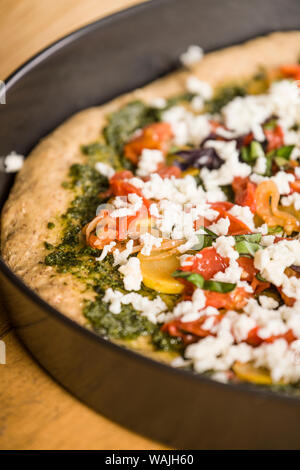 Geriebenen Mozzarella Käse auf einem hausgemachten Ungebackene, Vegetarisch, multi-grain Pizza mit dicker Kruste. Stockfoto