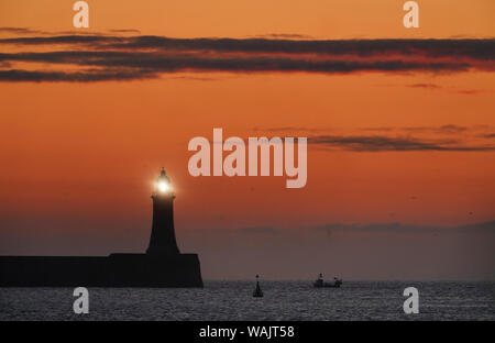 Ein Fischerboot Köpfe heraus zum Meer vorbei Tynemouth Leuchtturm, wie Temperaturen gesetzt sind für die Bank Holiday Wochenende zu steigen. Stockfoto