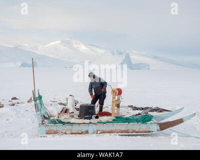 Fischer in Uummannaq Fjord, Grönland. Die fjorde sind im Winter gefroren, die Fischer mit Schlitten Löcher im Eis zu fahren. Sie unteren Linien mit Köder bis zu 1000 Meter. (Redaktionelle nur verwenden) Stockfoto