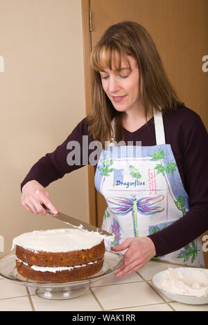 Frau Zuckerguss einen Karottenkuchen auf einem Glas Kuchen mit Sahne frosting. (MR, PR) Stockfoto