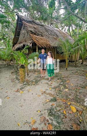 Kosrae, Mikronesien (FSM). Junges Paar Wanderweg von ihren traditionellen Palm/Bambus thatch Bungalow. (Redaktionelle nur verwenden) Stockfoto