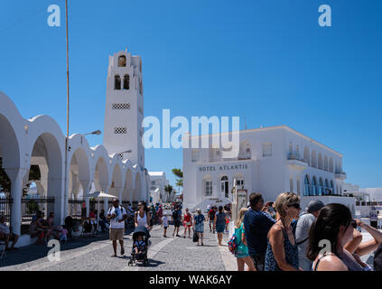 Fira, Griechenland - 12. Juli 2019: Touristen sammeln der Blick über die Klippe vor der Griechisch-orthodoxen Kathedrale und das Hotel Atlantis zu bewundern. Stockfoto