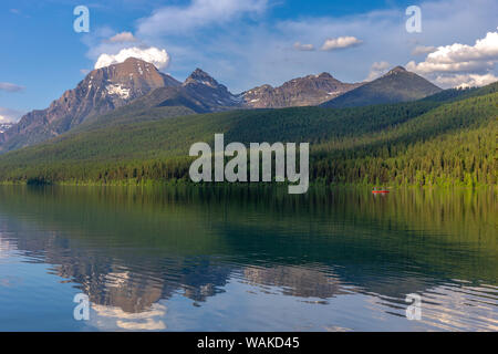 Angeln von einem roten Kanu auf den ruhigen Wassern der Bogenschütze See im Glacier National Park, Montana, USA Stockfoto