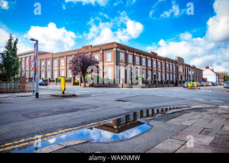 Nach schweren nächtlichen Regen Sonnenschein und blauen Wolken erscheinen am frühen Morgen, was im Regen Pfützen auf Christchurch Straße gegenüber Mobbs Miller h Stockfoto