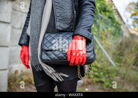 Meine Damen schwarz Fashion Handtasche mit roten Auto Handschuhe und Lederjacke mit grauen Schal Stockfoto